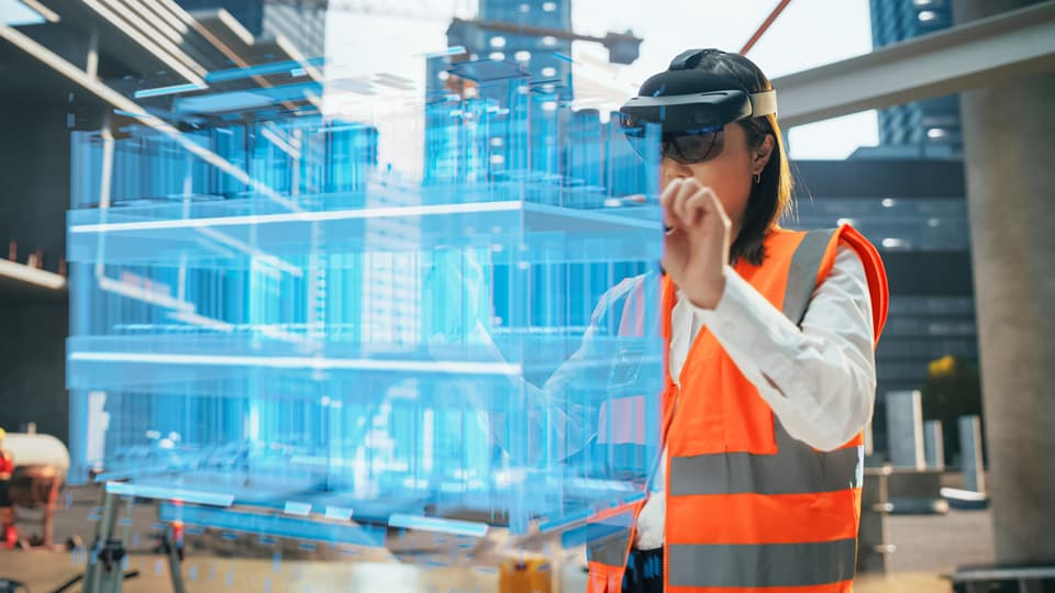 A female construction worker examines digital plans.